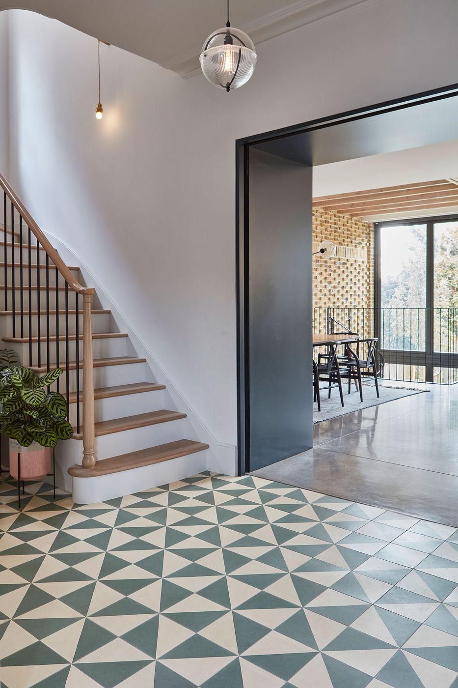 Reworked period hallway with patterned tiled floor and staircase, opening to the garden