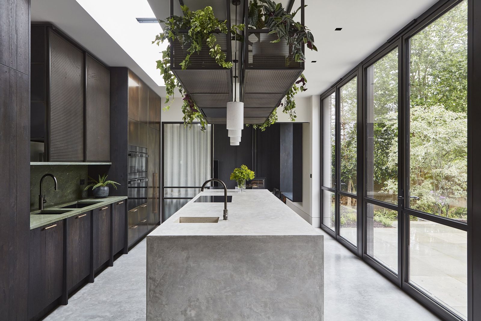 Long kitchen and dining space opening to the garden through full-height glazing