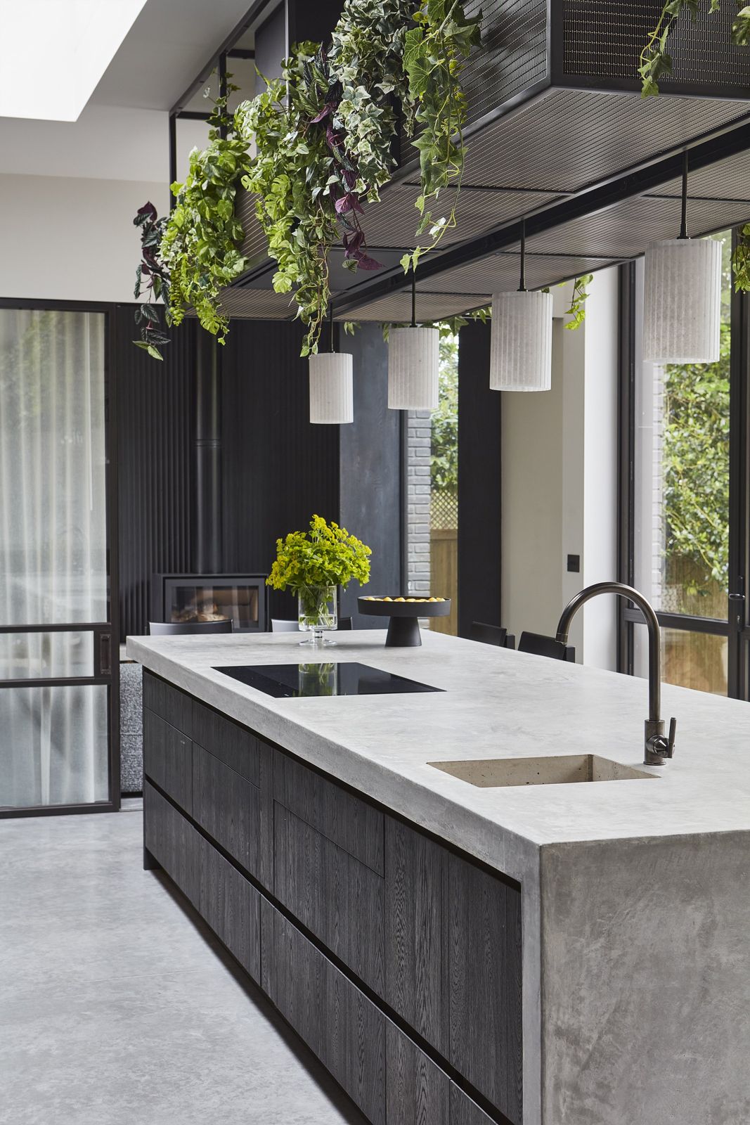 Dark timber island with concrete worktop and matt black tapware