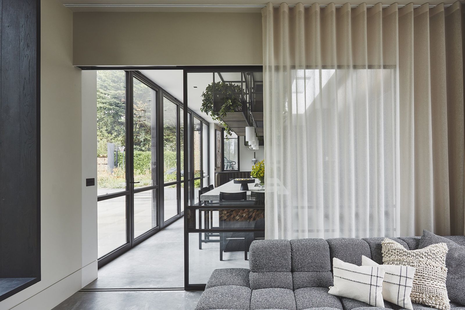 Curtained lounge with layered grey seating