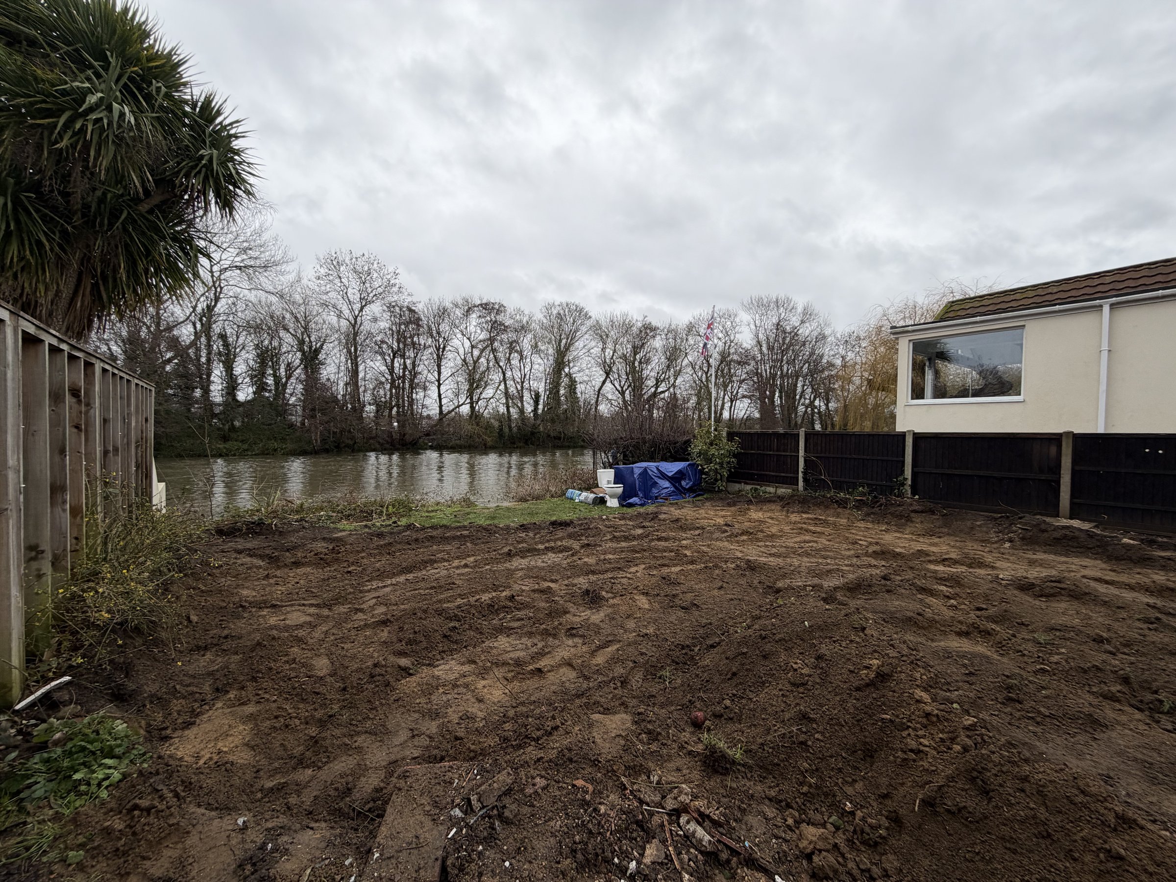 The cleared riverside plot running down to the water
