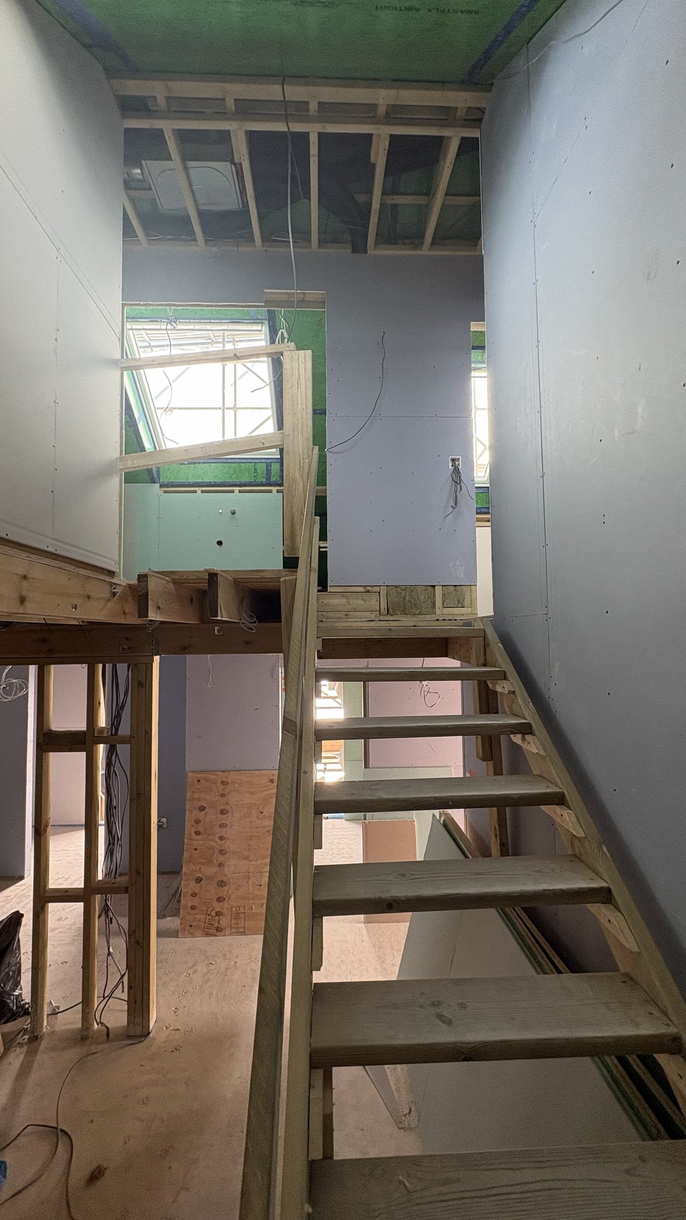 Temporary timber staircase rising through the stairwell