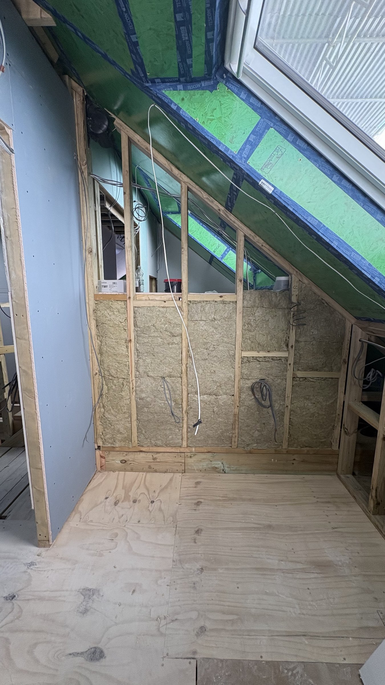 Mineral wool packed into the gable with taped airtight sheathing lining the rafters