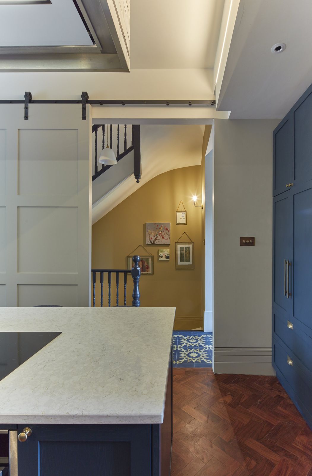 Kitchen island with marble worktop beside a sliding barn door