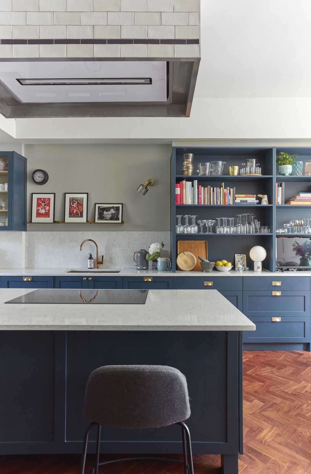 Deep blue kitchen with open shelving and herringbone oak floor