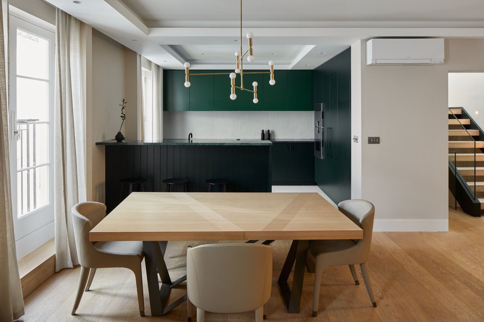 Open-plan dining space with dark kitchen beyond
