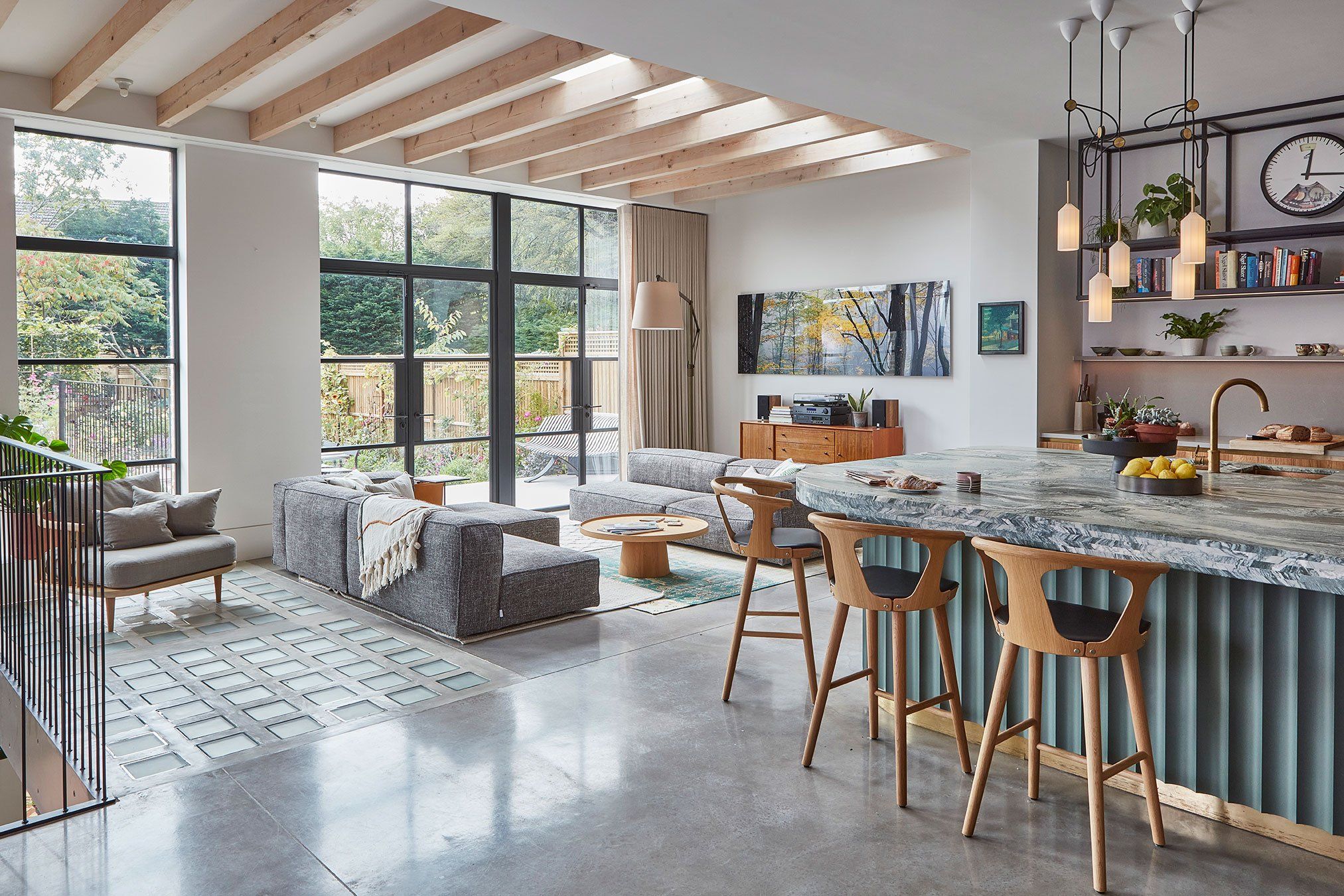 Open-plan living space with steel-framed glazing to a planted garden