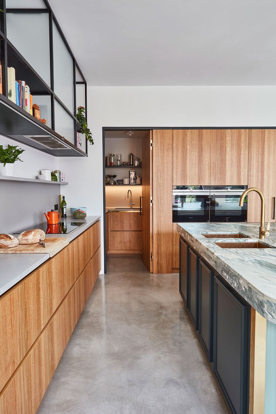 Kitchen with marble island, brass tapware, and oak joinery