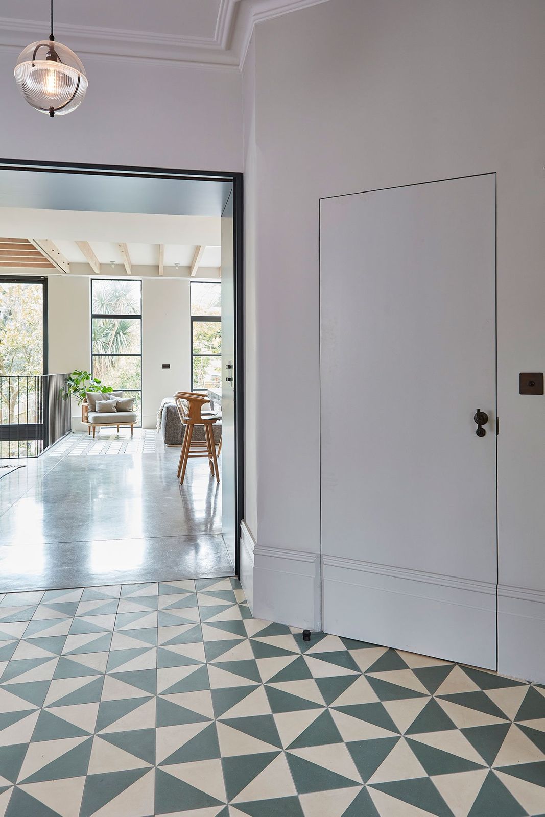 Hallway with geometric tiled floor and glazed pendant