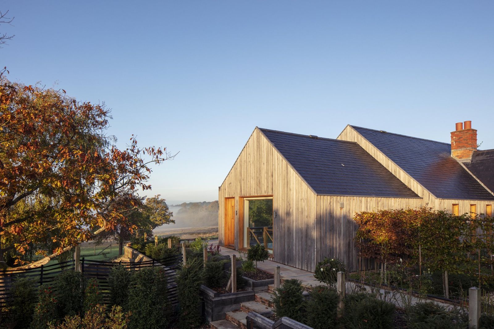 The house on the ridge above the garden in the morning light