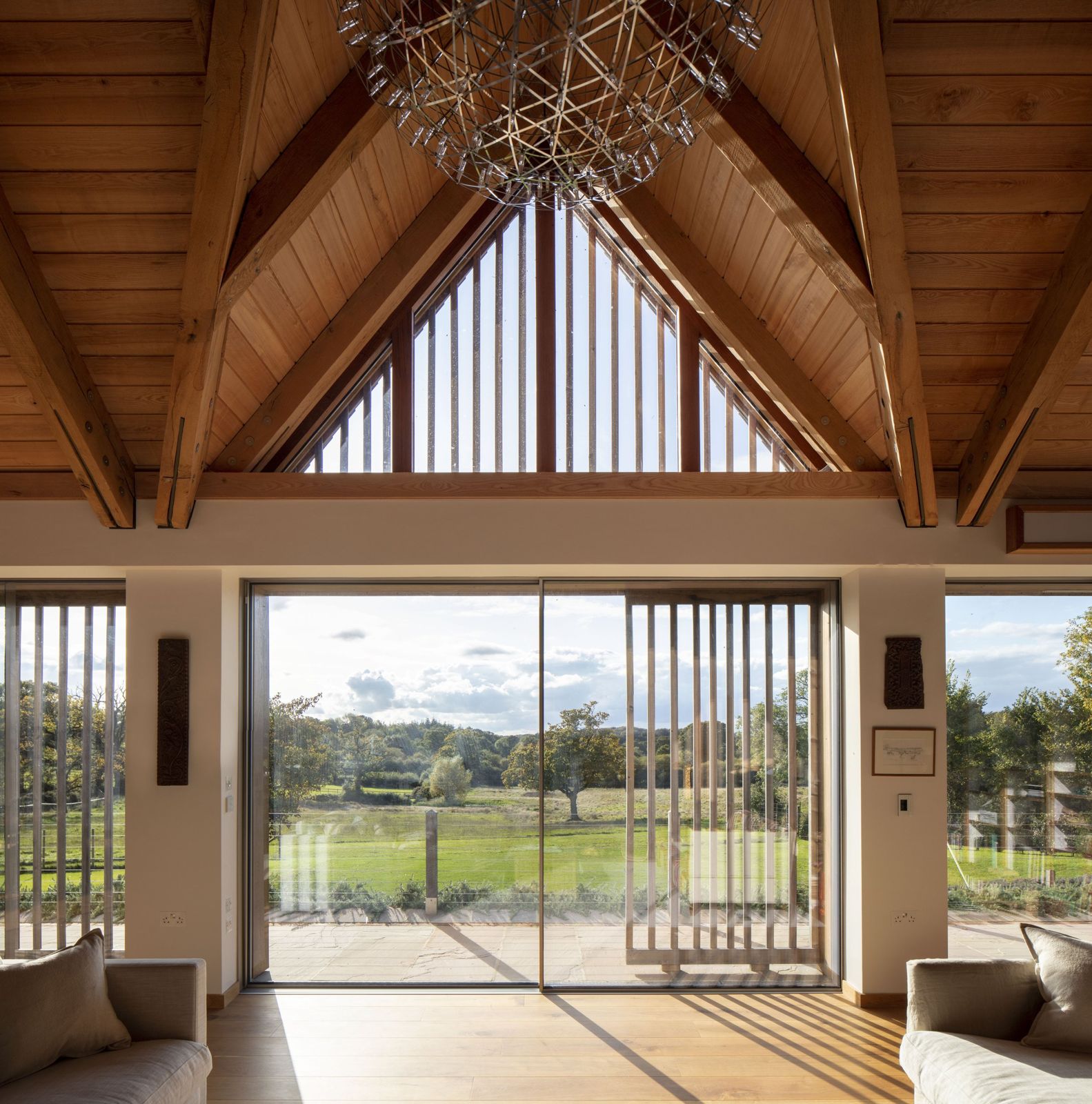 Living space under a vaulted timber roof opening to the garden