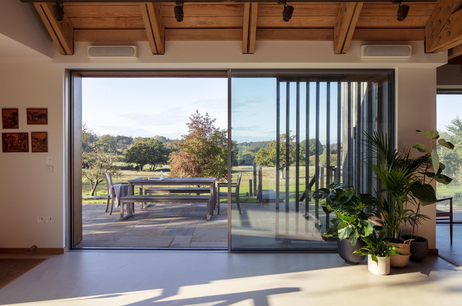 Sliding glazed wall opening the living space to the terrace and fields