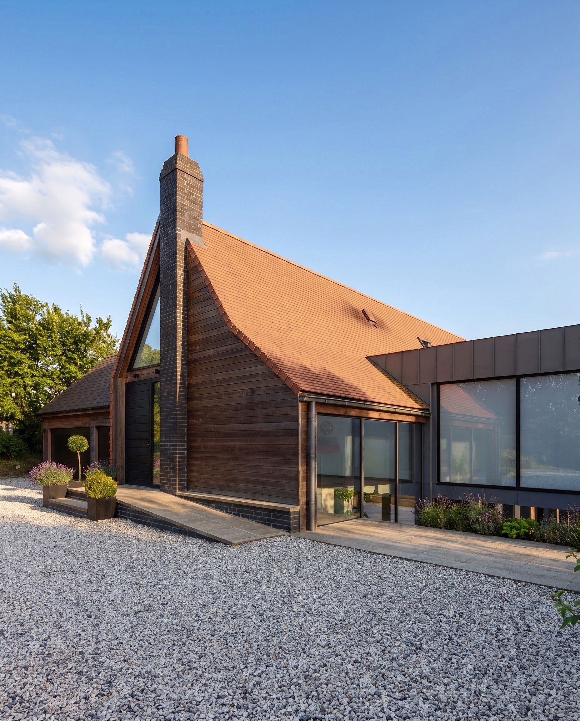 Steep tiled entrance gable with glazed apex and brick chimney