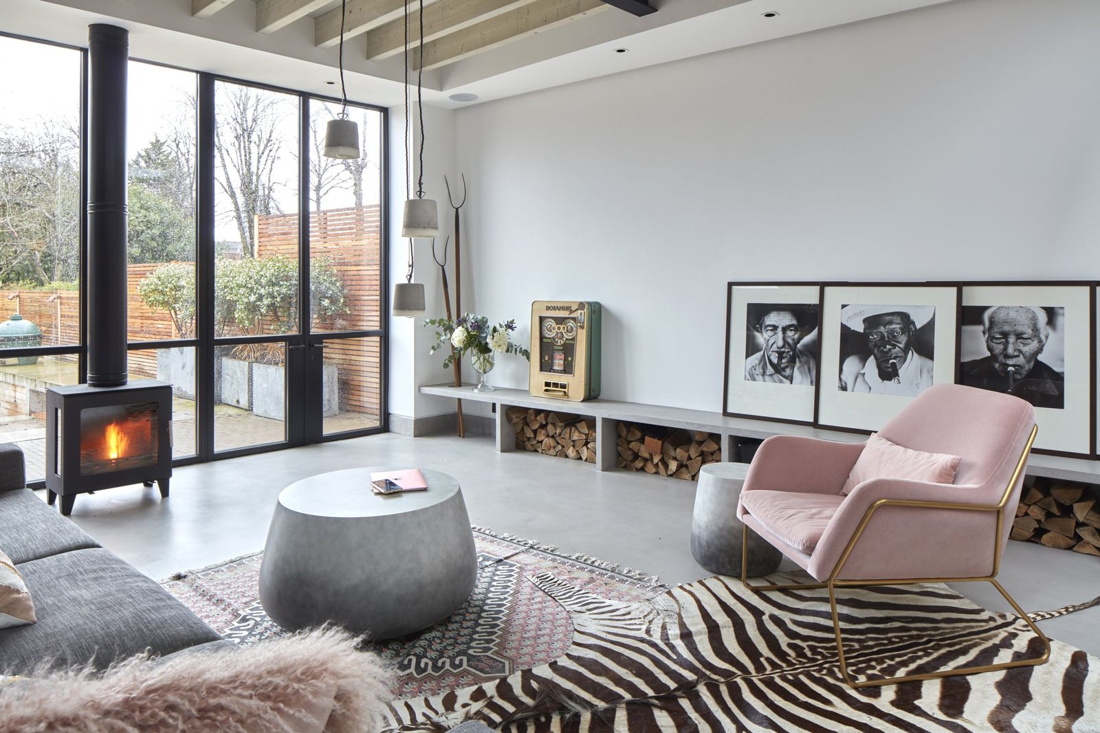 Lounge with zebra-print rug and pink armchair by the stove