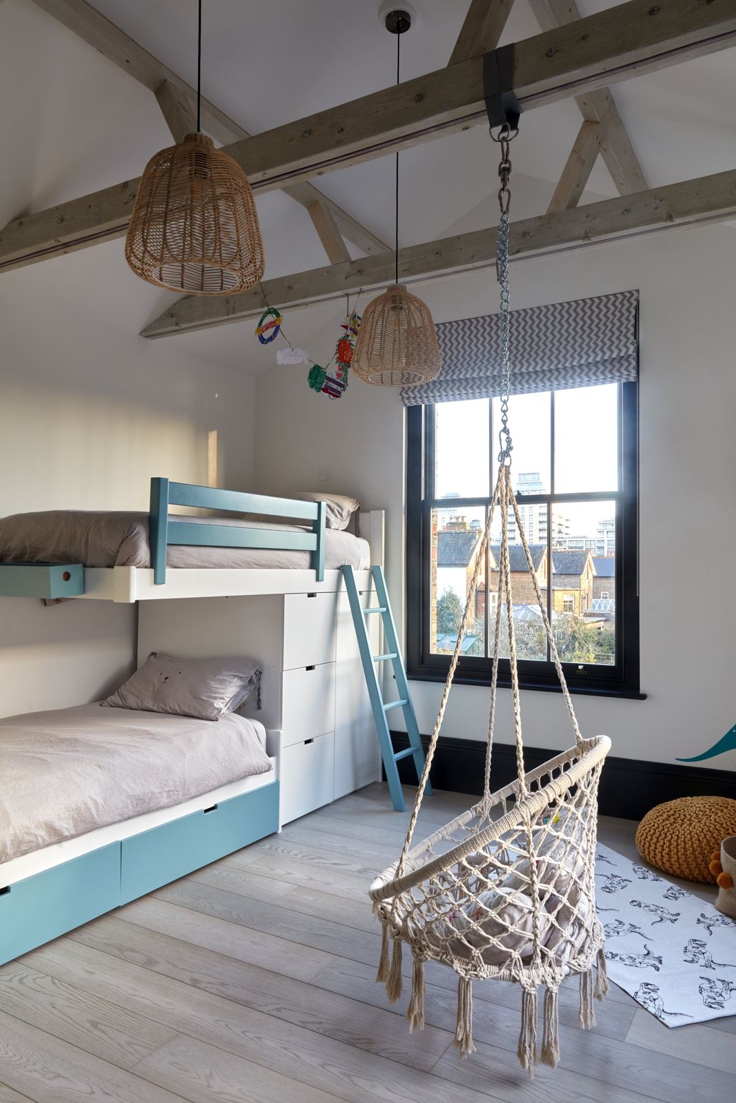 Children's room with bunk beds and hanging chair under exposed beams
