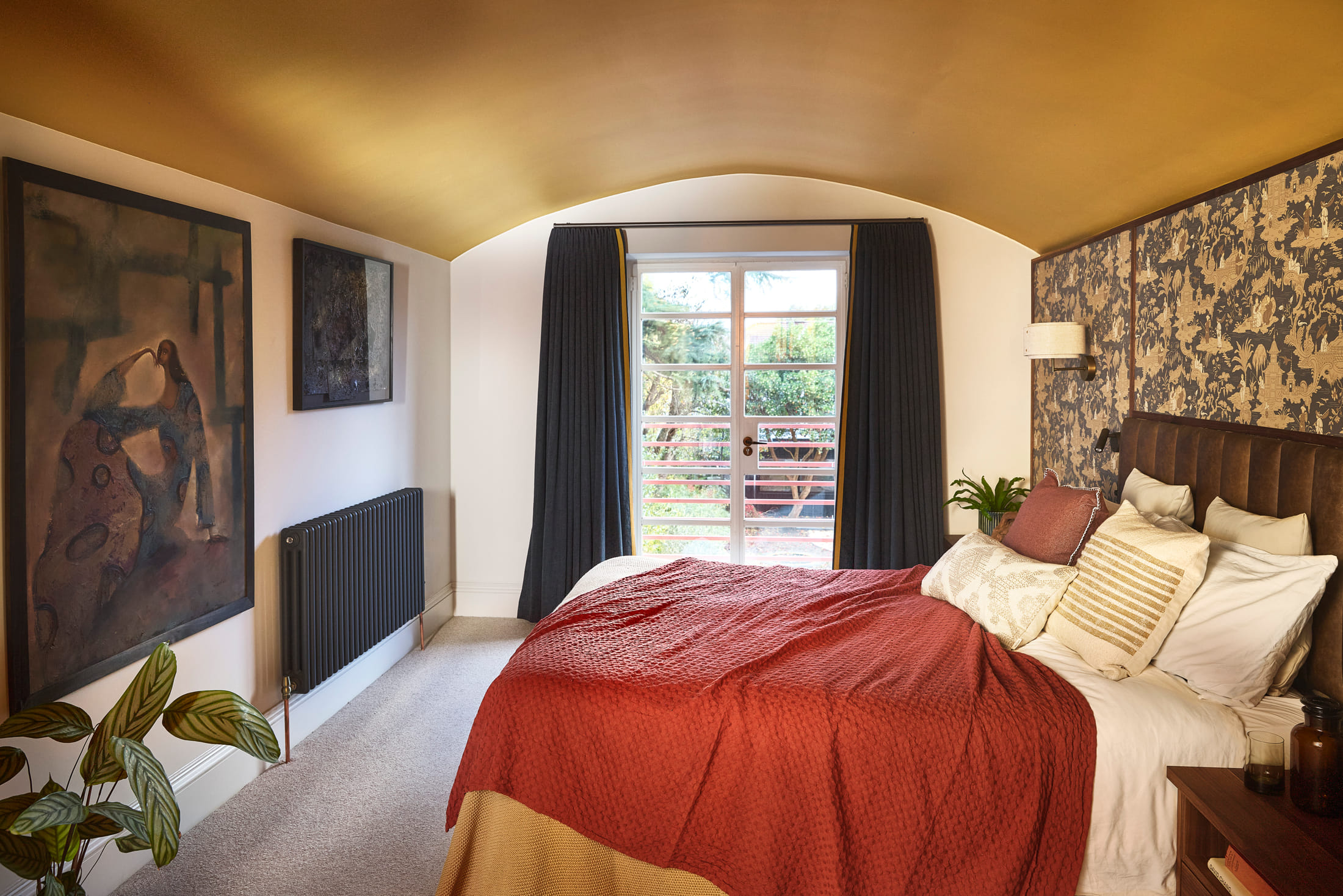 Bedroom under a barrel-vaulted ceiling finished in brushed brass