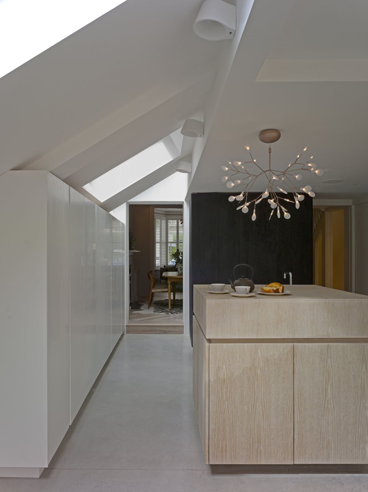 Kitchen under a pitched rooflight with pale joinery