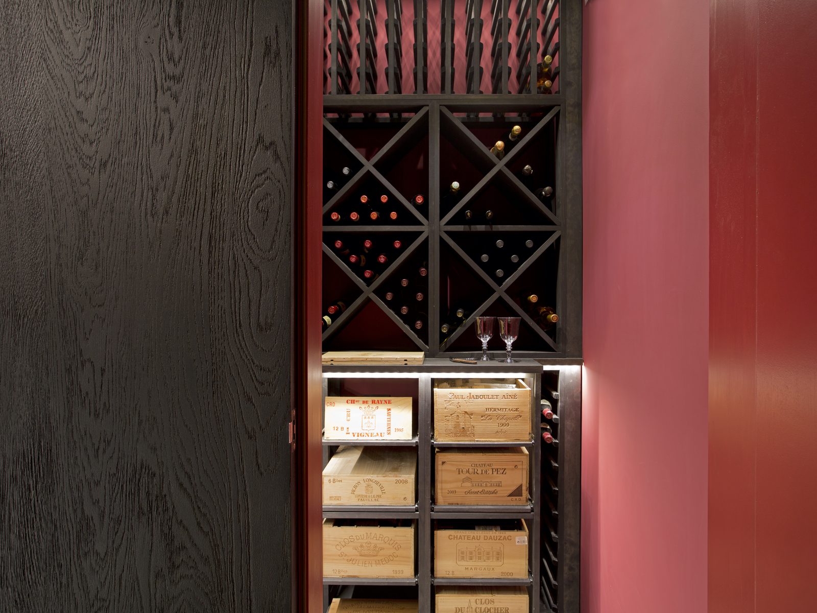 Wine store in dark-stained timber with a red panel