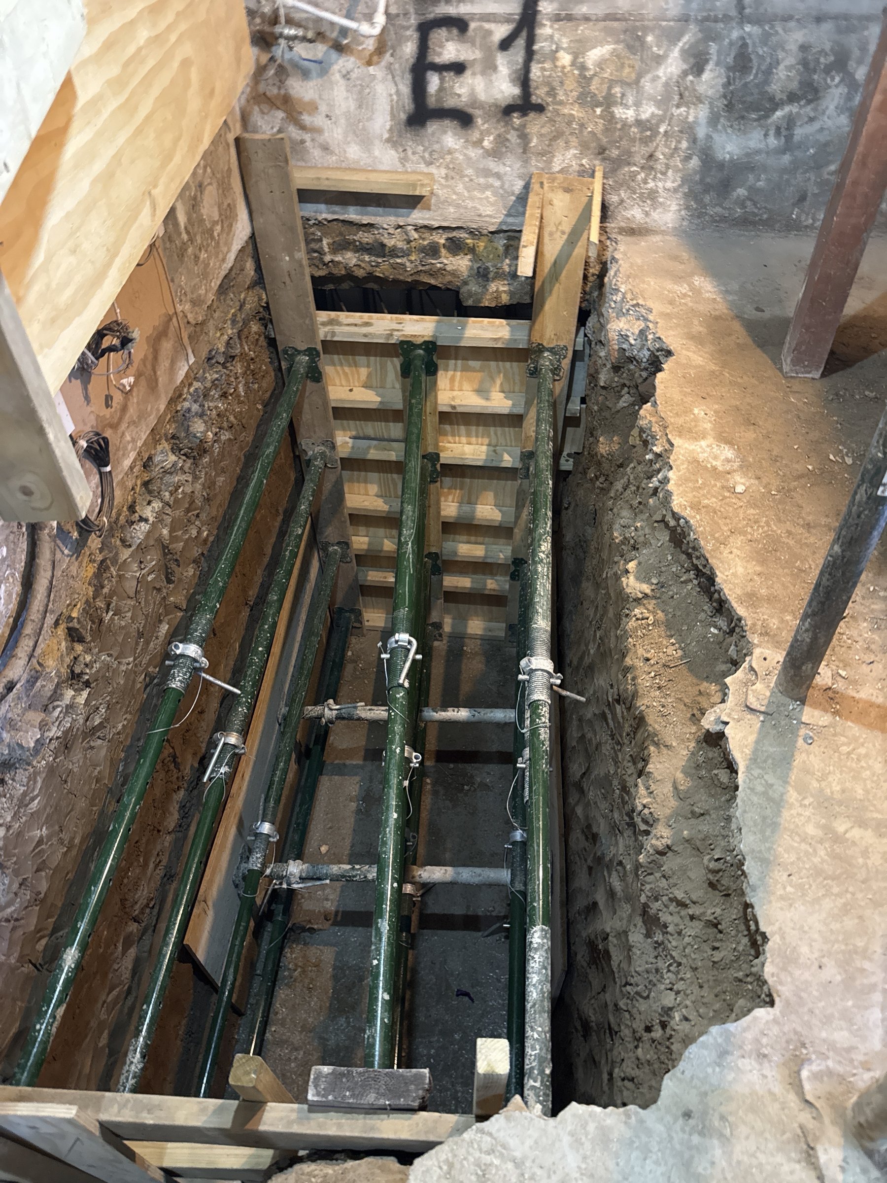 Underpinning pin E1 shuttered and braced with adjustable steel shores inside the old cellar